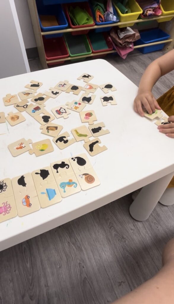 Child playing with animal puzzle pieces.
