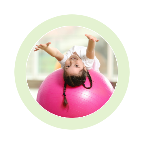 Child playing on a pink exercise ball.