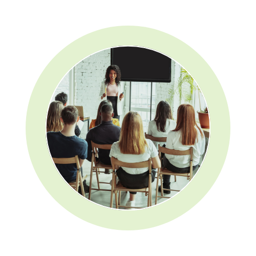 Woman presenting to an attentive audience in a modern classroom.